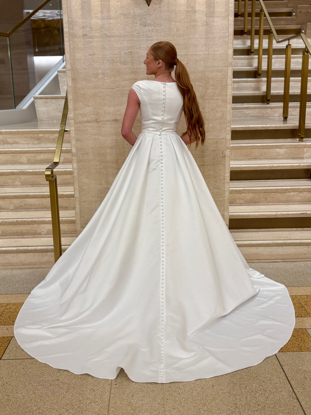 Woman in a white wedding dress standing on a staircase