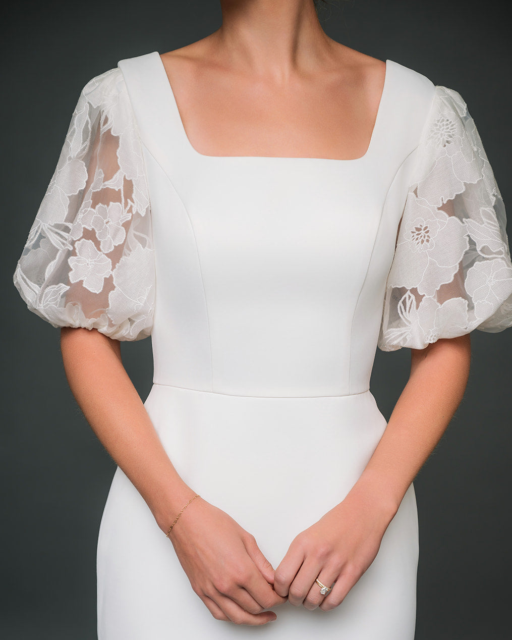 White lace dress with sheer sleeves on a dark background